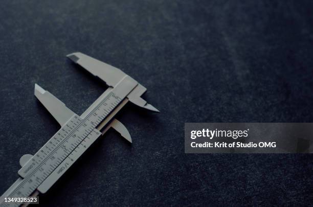a plastic vernier caliper on black floor - calibrador fotografías e imágenes de stock