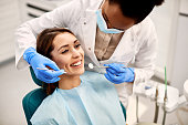 Young happy woman during dental procedure at dentist's office.