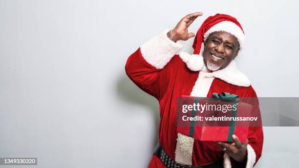 santa claus holding christmas gift on grey background - santa beard stock pictures, royalty-free photos & images