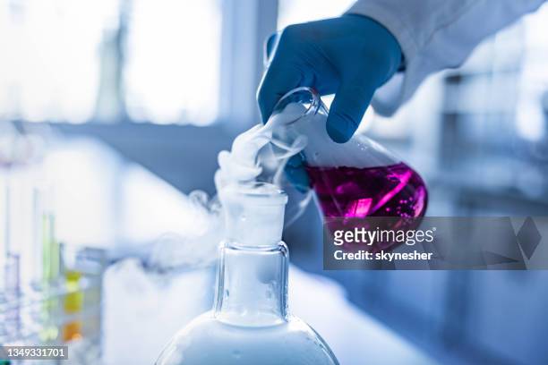close up of pouring smoke from laboratory flask. - scientific flask stock pictures, royalty-free photos & images