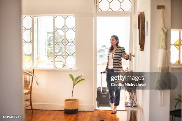 young woman with a suitcase arriving at her vacation rental accommodation - aankomst stockfoto's en -beelden