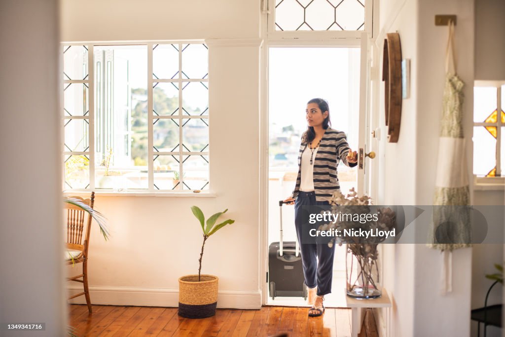 Young woman with a suitcase arriving at her vacation rental accommodation