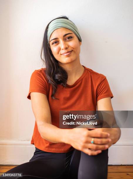 smiling young woman in sportswear relaxing after a yoga session - one portrait session stock pictures, royalty-free photos & images