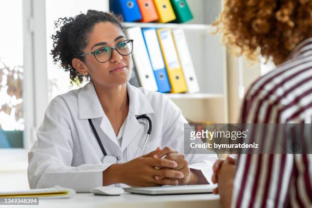 paciente que habla con su pediatra en un consultorio médico - abstinente fotografías e imágenes de stock