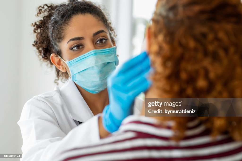 Medico che indossa la maschera chirurgica esaminando