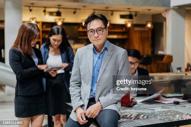 confidence business leader and his team in office - voorzitter stockfoto's en -beelden