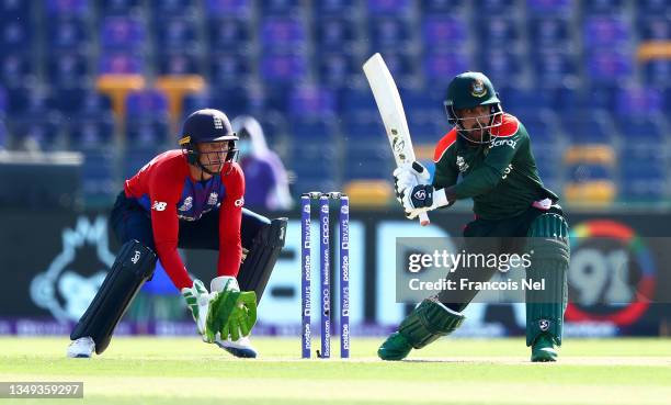 Liton Das of Bangladesh plays a shot as Jos Buttler of England looks on during the ICC Men's T20 World Cup match between England and Bangladesh at...