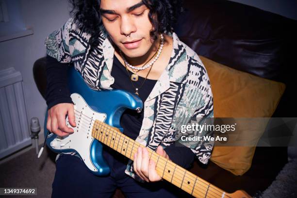 young man playing electric guitar at home - chitarra elettrica foto e immagini stock