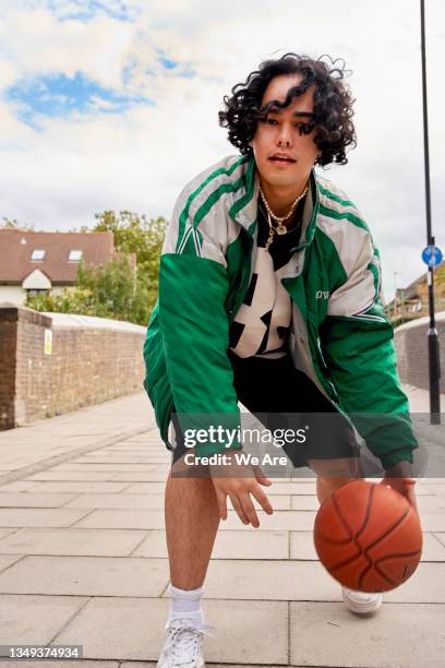 gen z man playing street basketball - sportif photos et images de collection