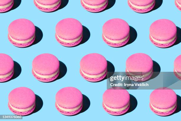 pattern made of tasty pink purple color macaroons on pastel blue background. - macaron stockfoto's en -beelden