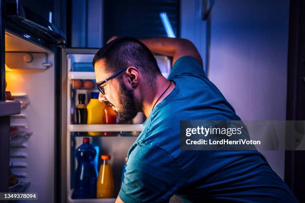 l'uomo che pensa a cosa mangiare - rimpinzarsi foto e immagini stock