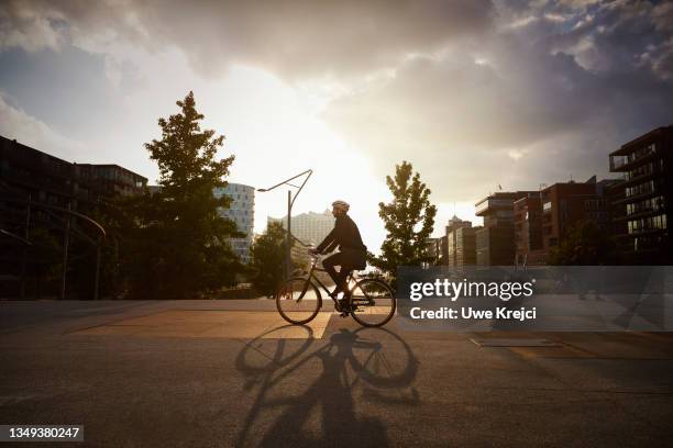 businessman cycling in the city - sunset road stock-fotos und bilder