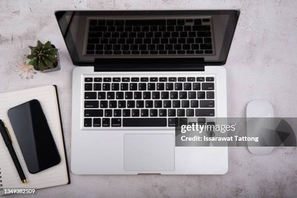 office stuff with notepad, laptop, smartphone and coffee cup top view shot. - notepad table stockfoto's en -beelden