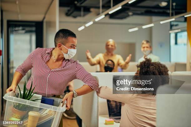 businesswomen elbow bumping with her colleague during pandemic time - touching elbows stock pictures, royalty-free photos & images