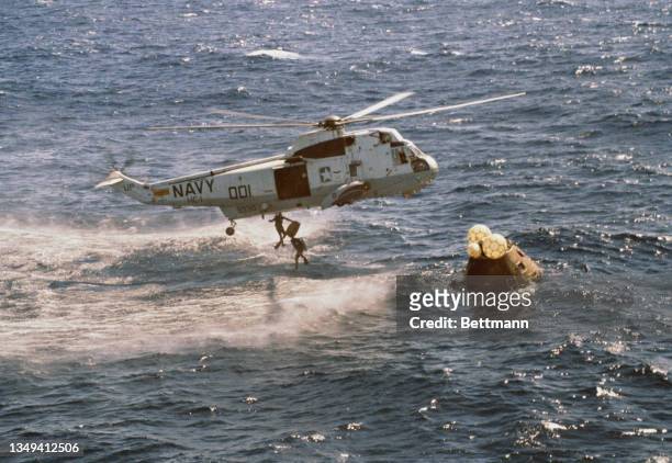 Navy pararescuemen jump into the Pacific Ocean at the start of the Apollo 16 recovery operations; Astronauts John W Young, Thomas K Mattingly II and...