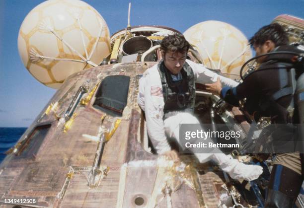 Apollo 16 Mission Commander John Young leaves the spacecraft nicknamed "Casper" during recovery operations in the Pacific Ocean 2,278 kilometers...