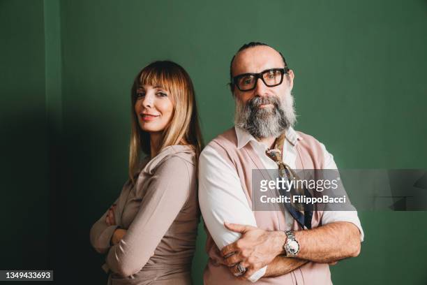 portrait of a mature adult couple against a green wall - business mature couple portrait bildbanksfoton och bilder