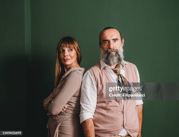 portrait of a mature adult couple against a green wall - business mature couple portrait bildbanksfoton och bilder