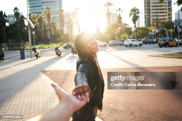 point of view of girlfriend holding hands of boyfriend while on vacations being happy and leading to the city. - leiden stockfoto's en -beelden