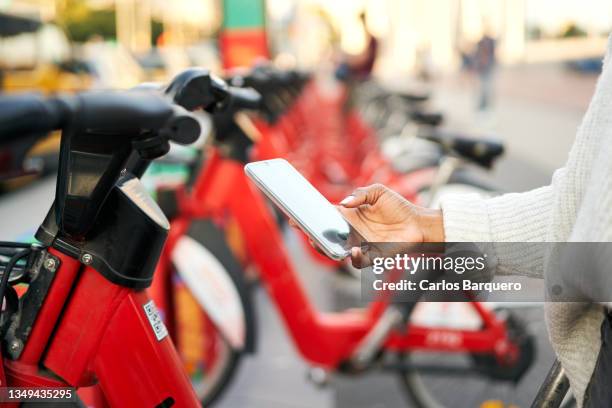 renting bicycle at the city with the smart phone using the qr code. - bike sharing stock pictures, royalty-free photos & images