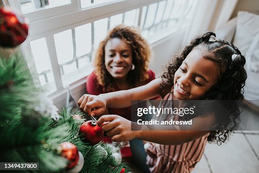Mutter und Tochter bereiten Weihnachtsbaum vor Mutter und Tochter bereiten Weihnachtsbaum vor