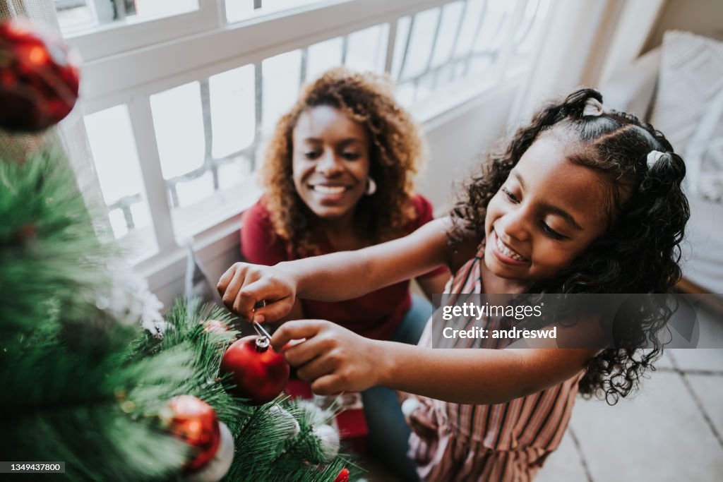 Mother and daughter preparing christmas tree