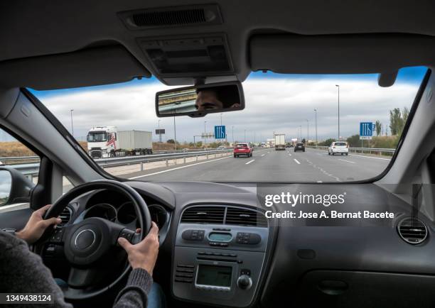 car point of view, young man driving a car on a two-lane highway with a lot of traffic - car point of view stock pictures, royalty-free photos & images
