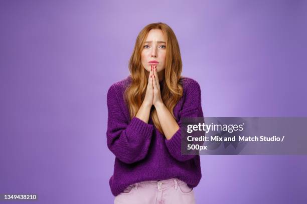 portrait of young woman standing against purple background - foxy lady stock-fotos und bilder