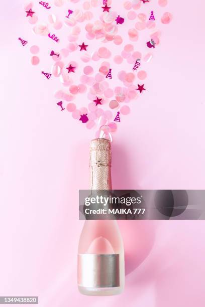 directly above champagne bottle exploding with pink sequins on pink background. christmas and new year concept. flat lay. mockup. - happy birthday wine stock pictures, royalty-free photos & images