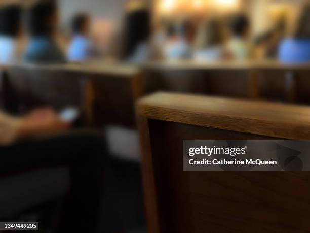 rear view of pews with unrecognizable people sitting - funeral stock photos et images de collection