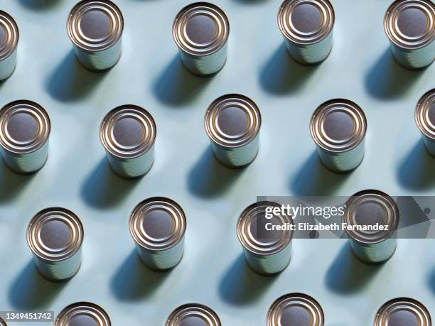 top view of repeated tin cans on soft blue background - lebensmittel in dosen stock-fotos und bilder