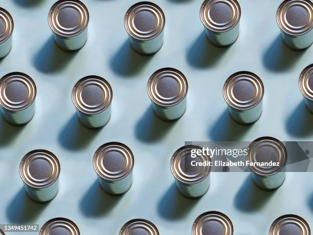 top view of repeated tin cans on soft blue background - coloured light patterns in a studio environment stock pictures, royalty-free photos & images