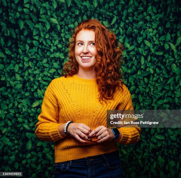 cute redhead woman, on green leaf background with yellow sweater - portrait close up woman 20 29 stock pictures, royalty-free photos & images