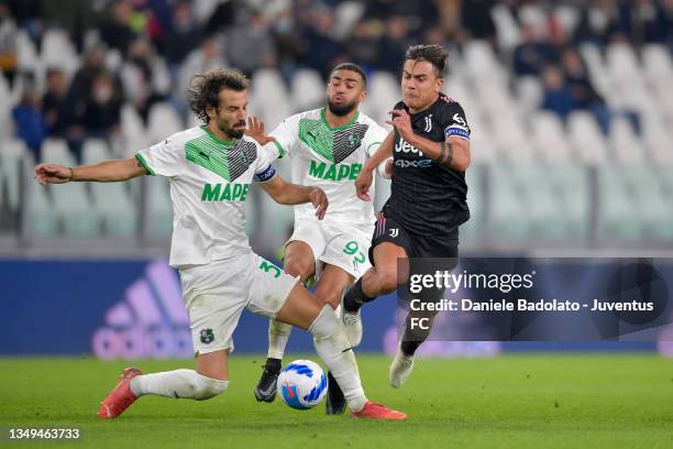 Paulo Dybala of Juventus is challenged by GianMarco Ferrari and Gregoire Defrel of US Sassuolo during the Serie A match between Juventus and US...