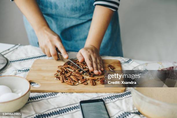 woman baking at home using online recipe - pecan nut stock pictures, royalty-free photos & images