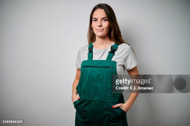 portrait of woman in overalls on white background - overalls stock pictures, royalty-free photos & images
