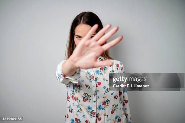 portrait of woman covering her face with her hand on white background - hand over bildbanksfoton och bilder
