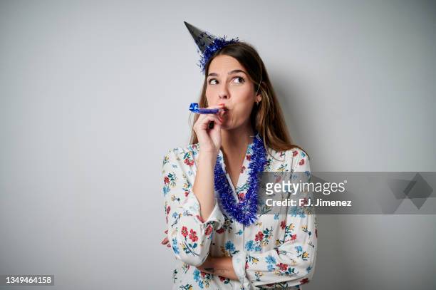portrait of woman dressed for new years eve party on white background - matasuegras fotografías e imágenes de stock