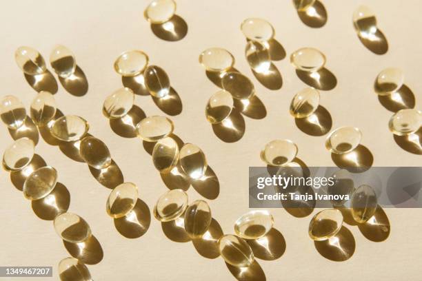 soft vitamin d capsules on a beige background. - fish oil ストックフォトと画像