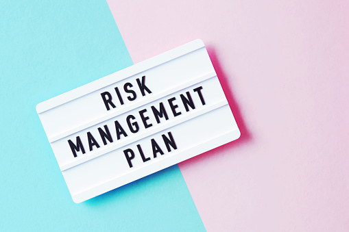 Risk Management Plan Written White Lightbox Sitting On Pink And Blue Background