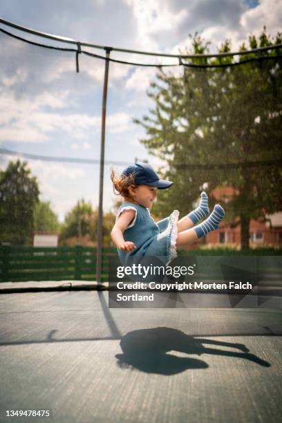 a child jumping on the trampoline - trampoline equipment stock-fotos und bilder