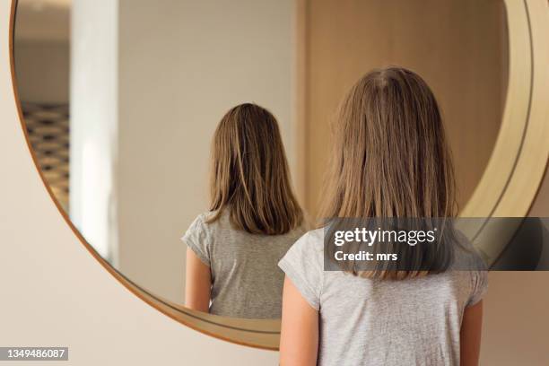 girl standing by the mirror - girl in mirror stockfoto's en -beelden