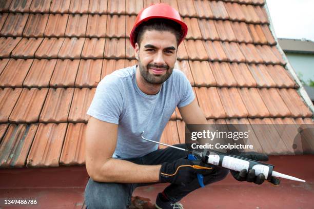 young man repairing a roof. - dakdekker stockfoto's en -beelden