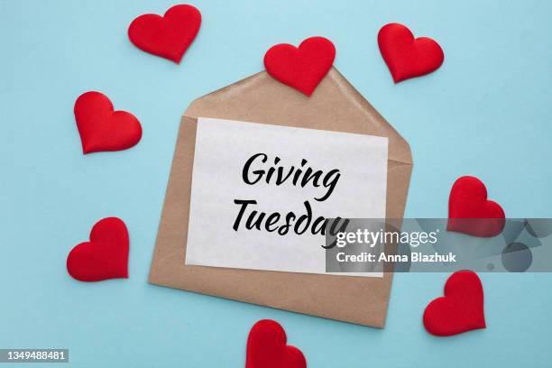 giving tuesday concept. envelope with text and red hearts over blue background. - giving tuesday stock pictures, royalty-free photos & images