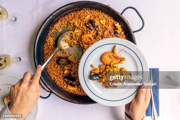 man eating seafood paella at the restaurant, personal perspective view - bivalve stock pictures, royalty-free photos & images