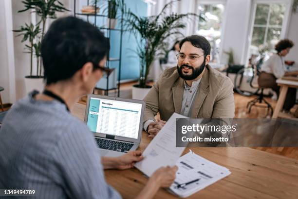 hombre de negocios confiado discutiendo con mujer de negocios en la oficina - interview fotografías e imágenes de stock