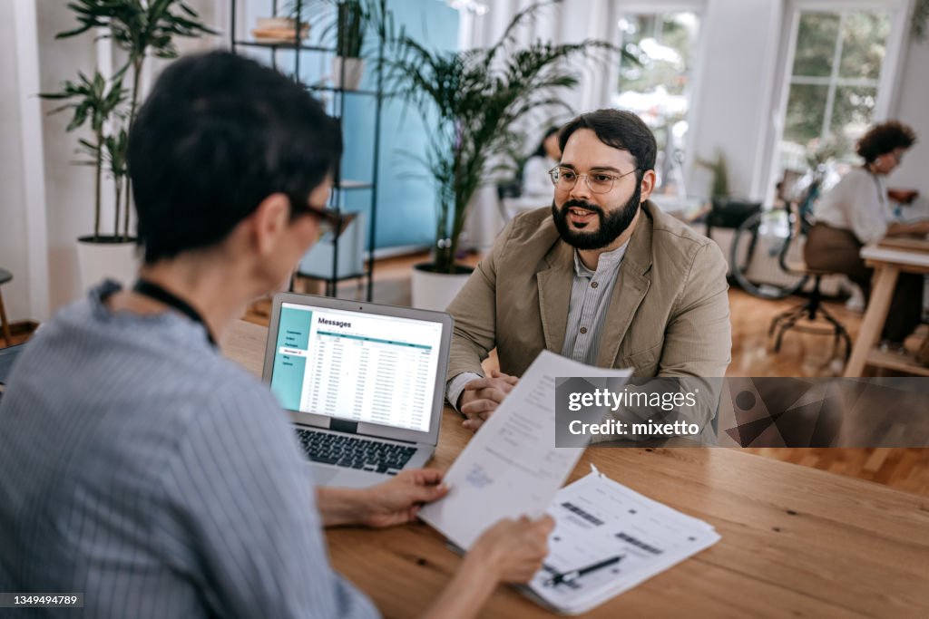 Confident businessman discussing with businesswoman at office