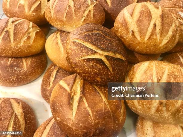 closeup of freshly baked artisanal bread, organic gourmet loaves, round rustic farmhouse boules, traditional european baking, homemade white bread in rural france - pain boule photos et images de collection