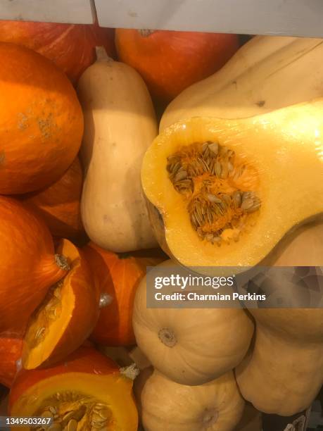 fresh autumn produce at farmers market, fall vegetables, organic pumpkin and butternut squash, pile of whole and cut winter squash on market stall for halloween - pumpkin soup stock-fotos und bilder