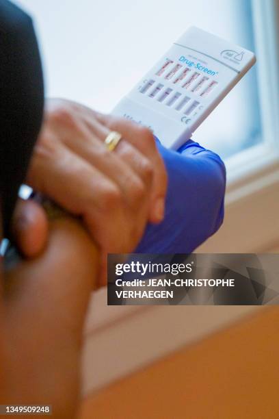 Nurse reads the results of a urine drug test of a drug-addicted patient at the 'Centre de soins, d'accompagnement et de prévention en addictologie' -...